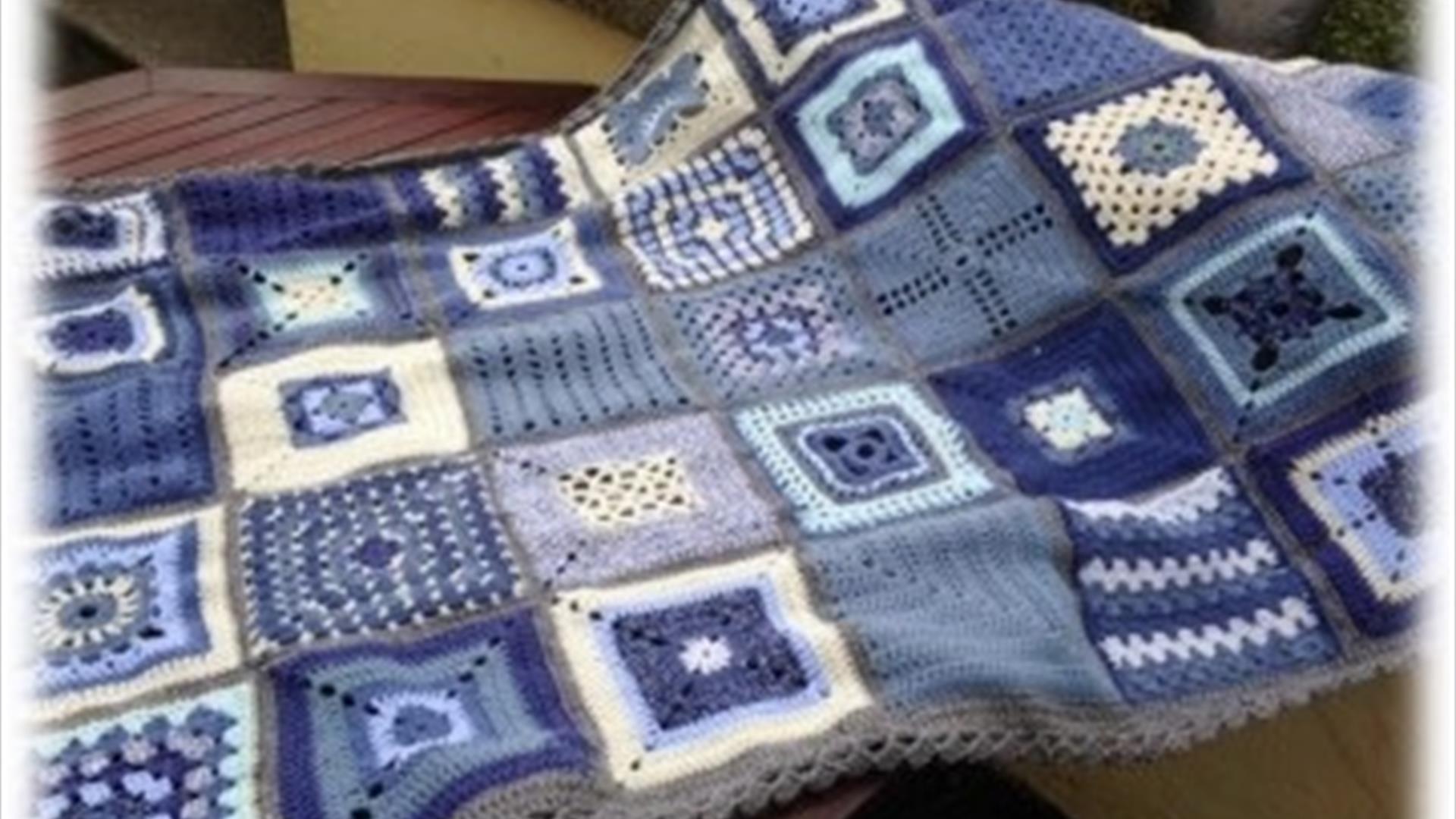 Image of a purple and white crochet blanket