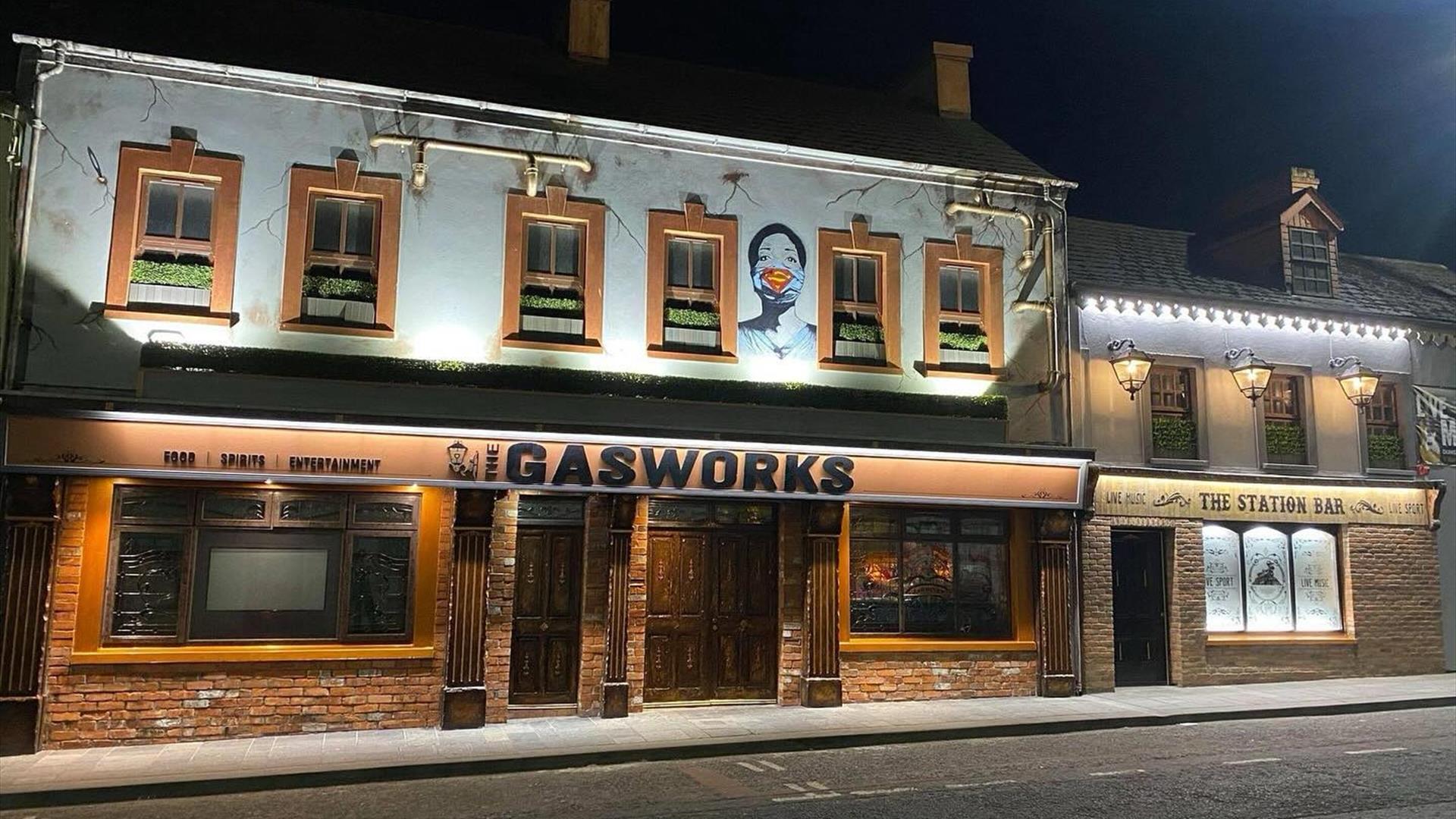 Image of the outside of the building with old brickwork and downturn lights.
