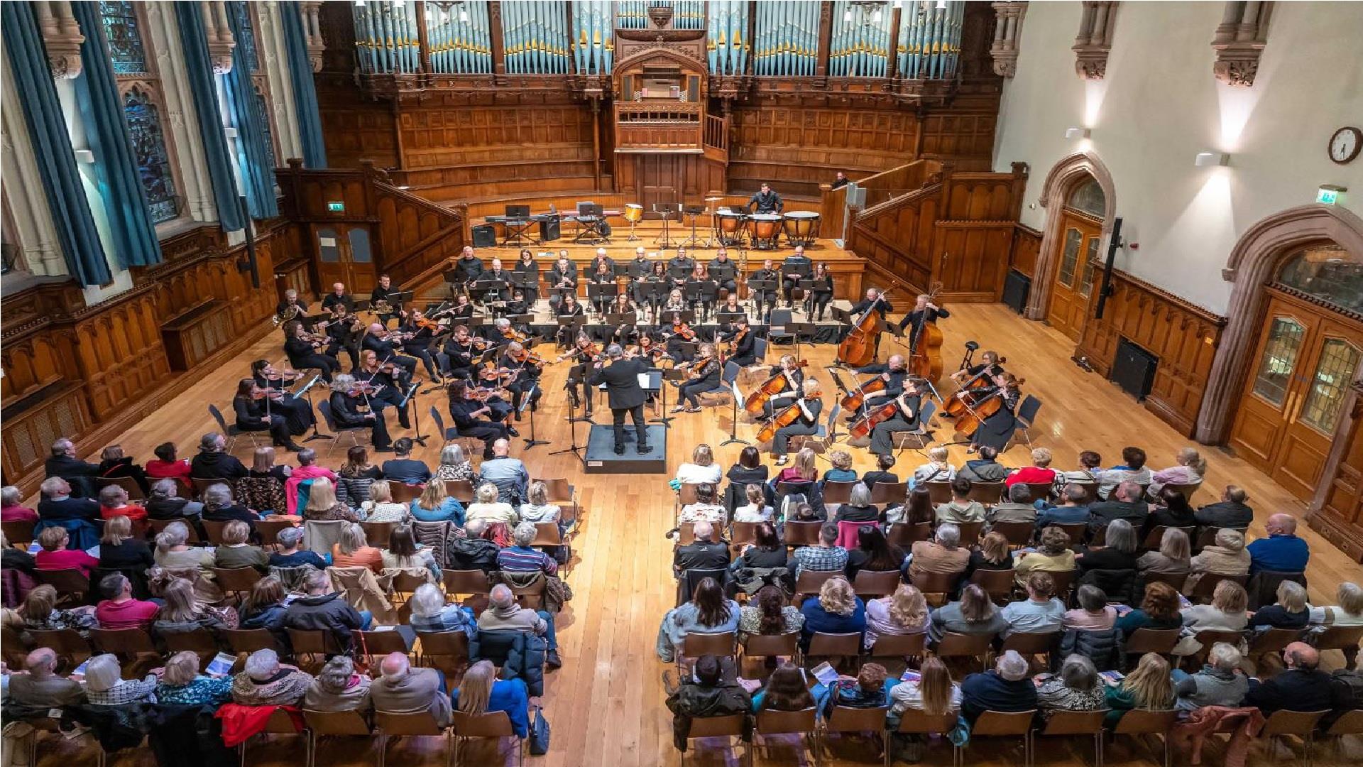 Image of the orchestra playing in front of an audience