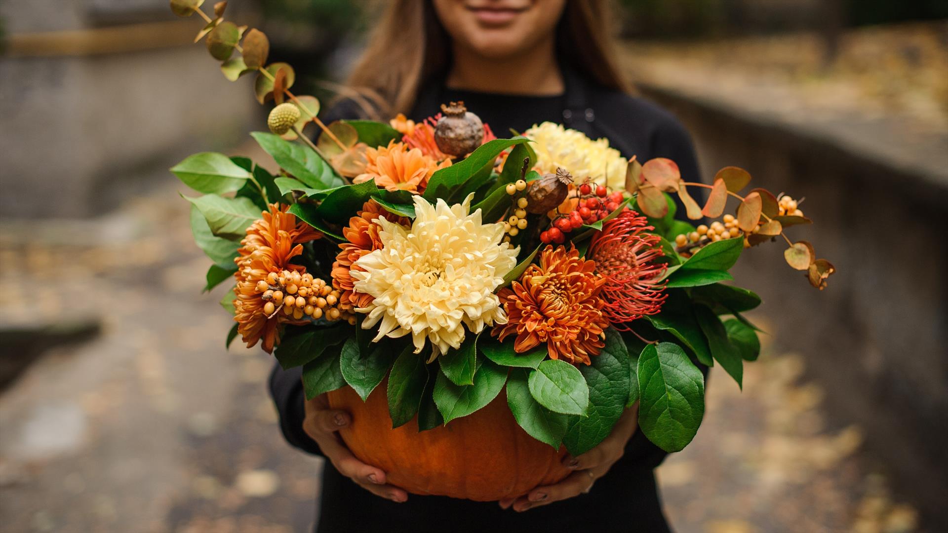 A pumpkin filled with autumnal flowers