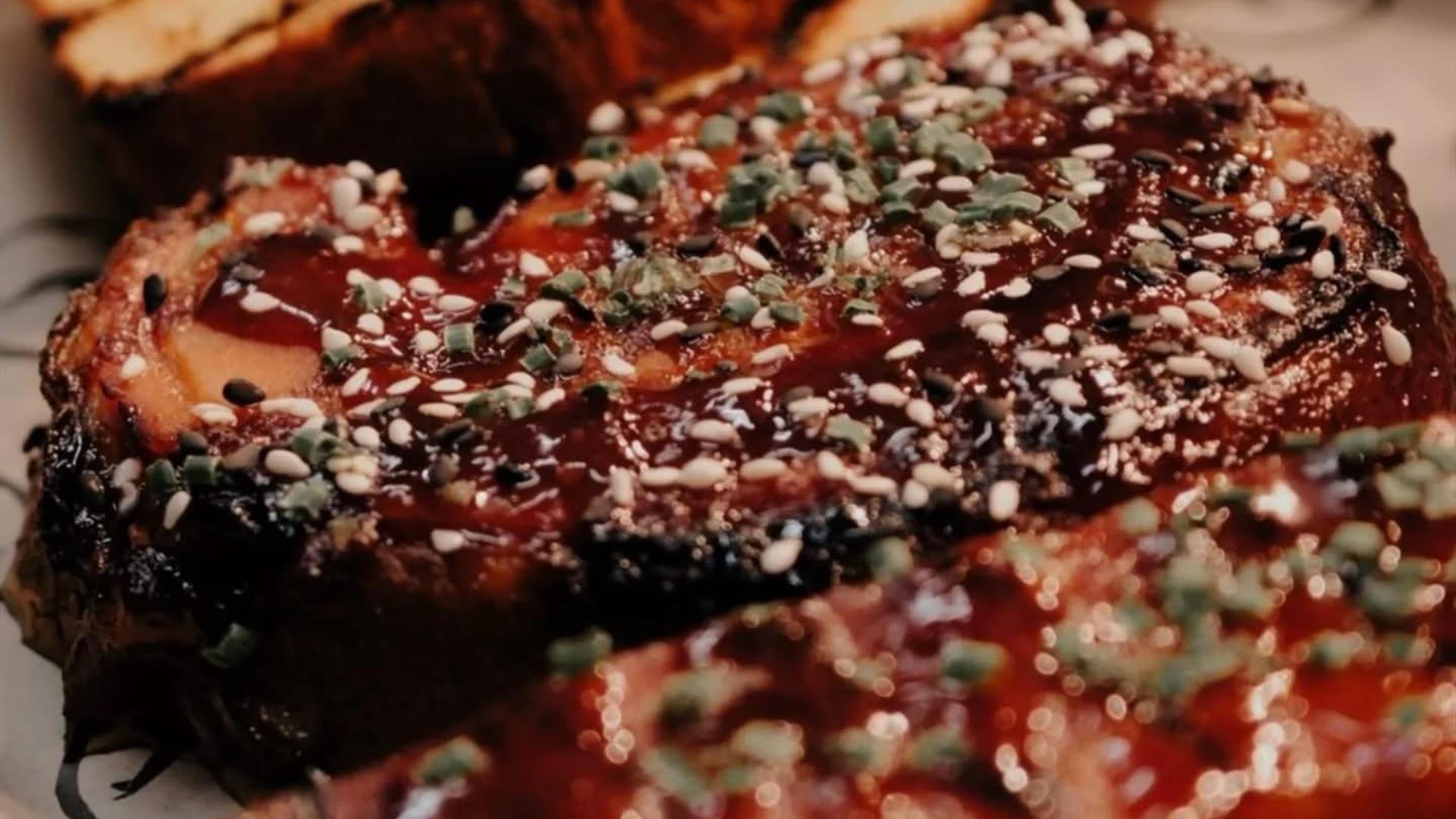 BBQ meat sprinkled with herbs and garlic bread slices