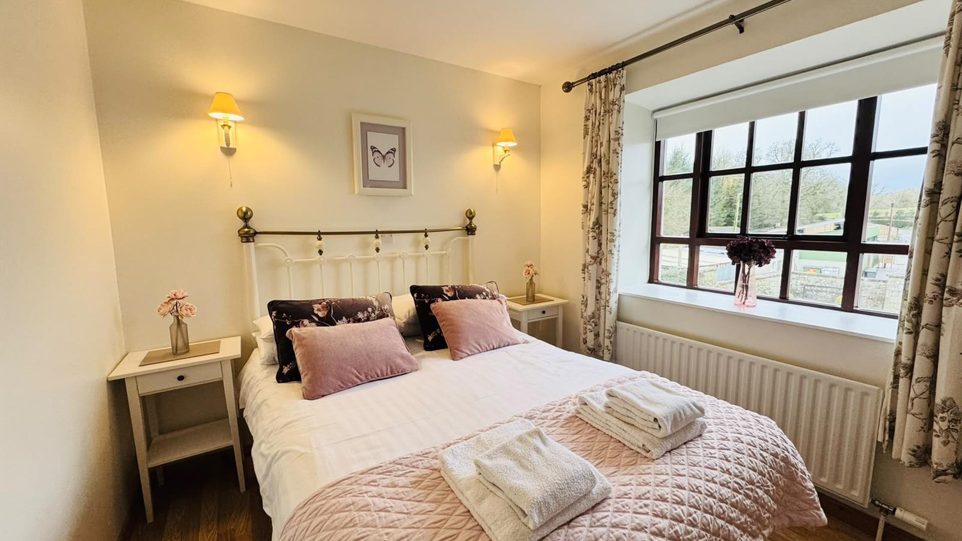 Double bedroom with pink accents and large window.