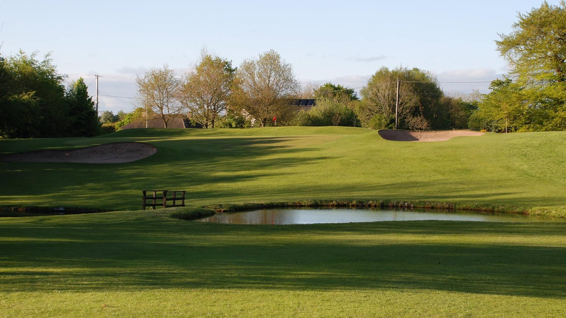 image of the gold course with sand bunker and small lake