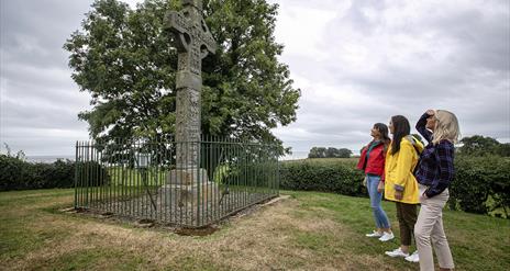 Three ladies looking up at Ardboe High cross