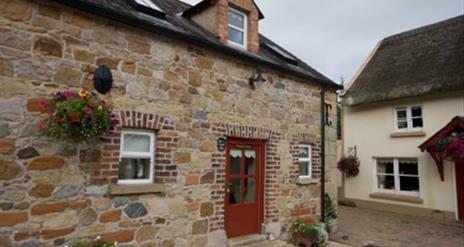 entrance to cottage with red door and stone walls