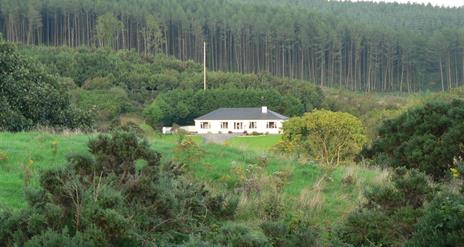 An image of a secluded house from across a field
