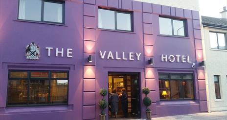 outside image of The Valley Hotel, with purple walls and black window frames and door