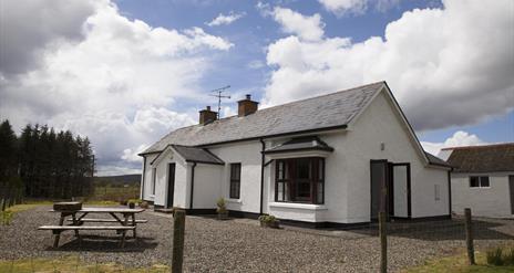 outside image of house with picnic table at front