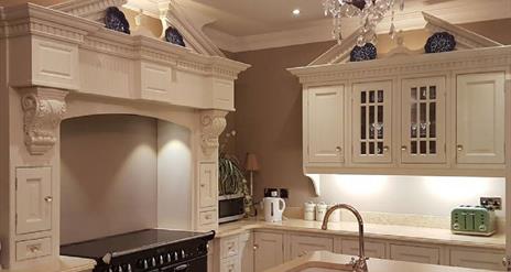 Modern kitchen with range cooker, cream cabinets and sink in the island