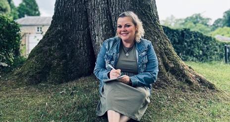 Fionnuala Cassidy sitting in front of a tree.