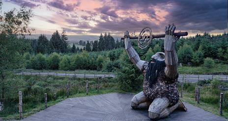 Ceoldán, the Stargazer, kneeling on a timber boardwalk