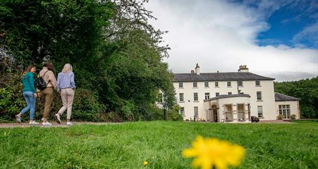 Three girls walking towards Lissan house on a sunny day