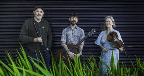 2 men and 1 lady holding their traditional instruments - guitar, fiddle and flute