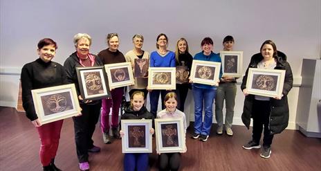 Image of a group of people holding up there copper crafts