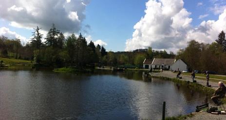 Anglers sat around a lake fishing