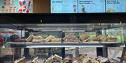 Counter full of traybakes in a cafe