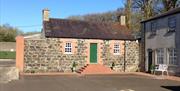 The exterior of a cottage with a green door