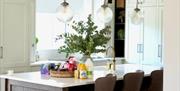 Modern kitchen with island seating and pendant lights.
