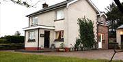 Image of a white two story house with climbing vines up the side