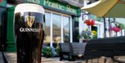 Pint of Guinness on table outside the front of Friels Bar