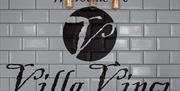 White and black tiled splash back spelling Villa Vinci.