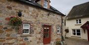 entrance to cottage with red door and stone walls