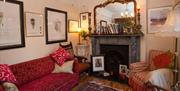 Living area with sofa and armchair, fireplace and mirror