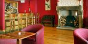 lounge area with bar, wood burning stove and tables and chairs