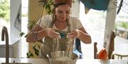 Image of one of the local producers Bronagh Duffin from Bakehouse NI sieving flour into a bowl