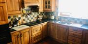 Kitchen with black countertop and neutral tile backsplash