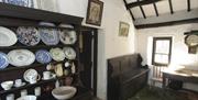 Dresser with different china, a wooden bench seat and an old picture