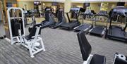 A gym with a patterned floor and mirrors surrounding