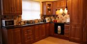 Wooden kitchen units with a tiled backsplash