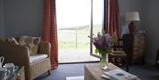 living area with patio doors and armchairs looking to mountains