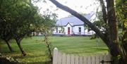 front garden of Rose Cottage with large grass area and trees