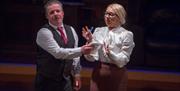 Male and female actors dressed in suits like office workers on stage