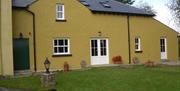 outside image of The Homecoming Barn with patio doors and grass garden