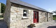 entrance to cottage with red door and stone walls