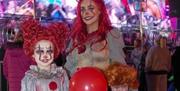 Woman and 2 children dressed as halloween clowns