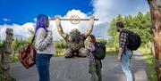 Three people looking at the giant on the timber boardwalk