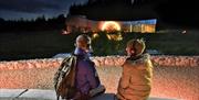 A couple with headphones watching the outdoor projection of the sun