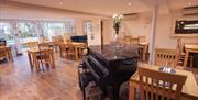 A restaurant seating area with a piano