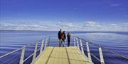 A family at the end of the board walk overlooking the water