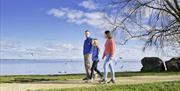 A family on a walk beside the water