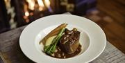 A plate of food in a restaurant with fillet of beef and broccoli