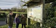 A group of walkers looking at a large map