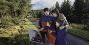 Family looking at signage on the OM Solar Walk