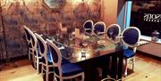 an image of the glass dining table and blue chairs in the restaurant