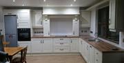 kitchen area with neutral colour scheme and wooden table and chairs