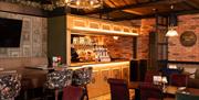 Black Sheep Restaurant with high beam ceilings, brick walls and small lit up bar